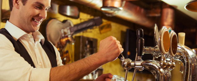 A man pouring a glass of beer from a tapper