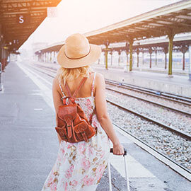 A woman with a backpack waiting at a train station