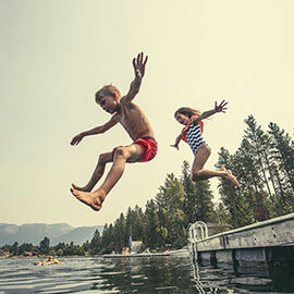 Children jumping into a lake