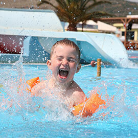 A boy splashing around in a pool