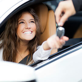 A woman in a car receiving a set of keys