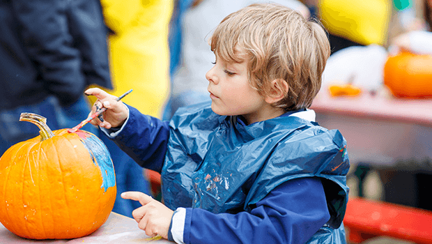 boy painting pumpkin