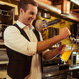 A man pouring a glass of beer from a tapper