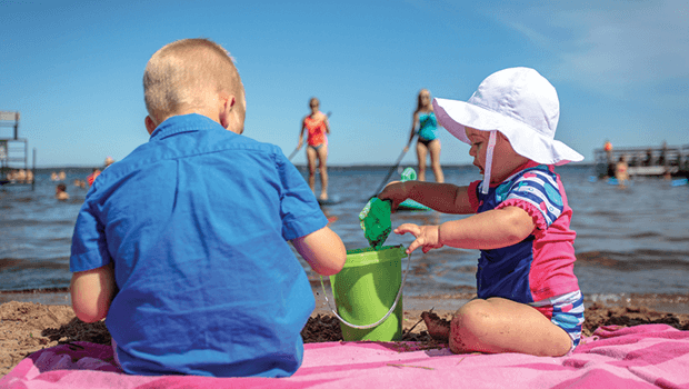 kids playing on sand beach by water