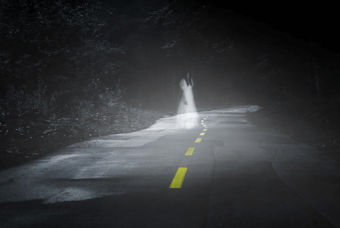 A ghostly figure down a dark road